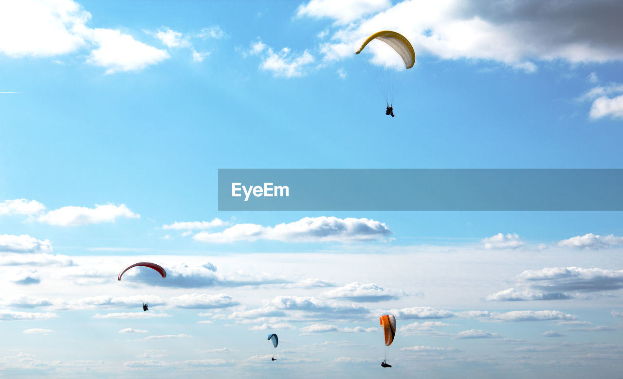 LOW ANGLE VIEW OF PERSON PARAGLIDING AGAINST SKY