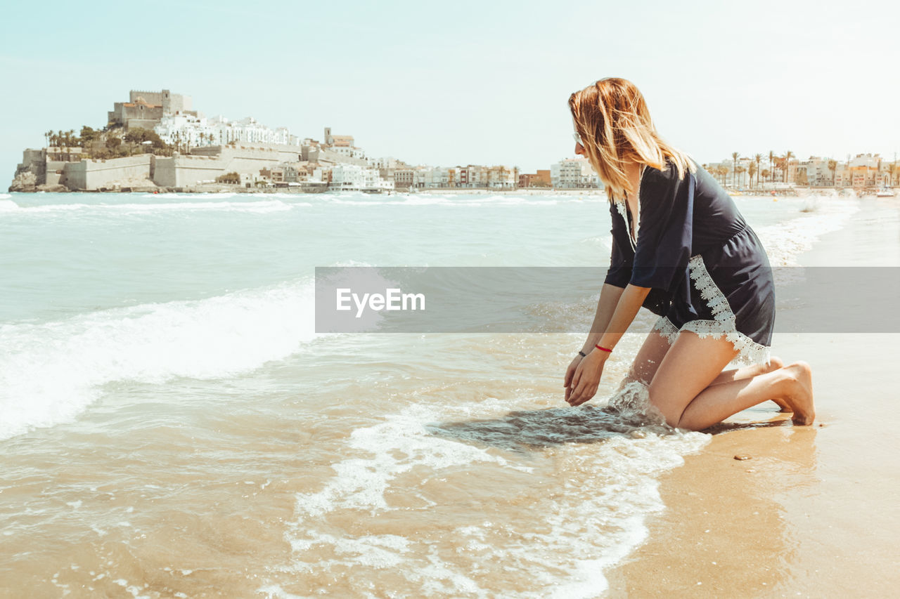 Side view of young woman at beach