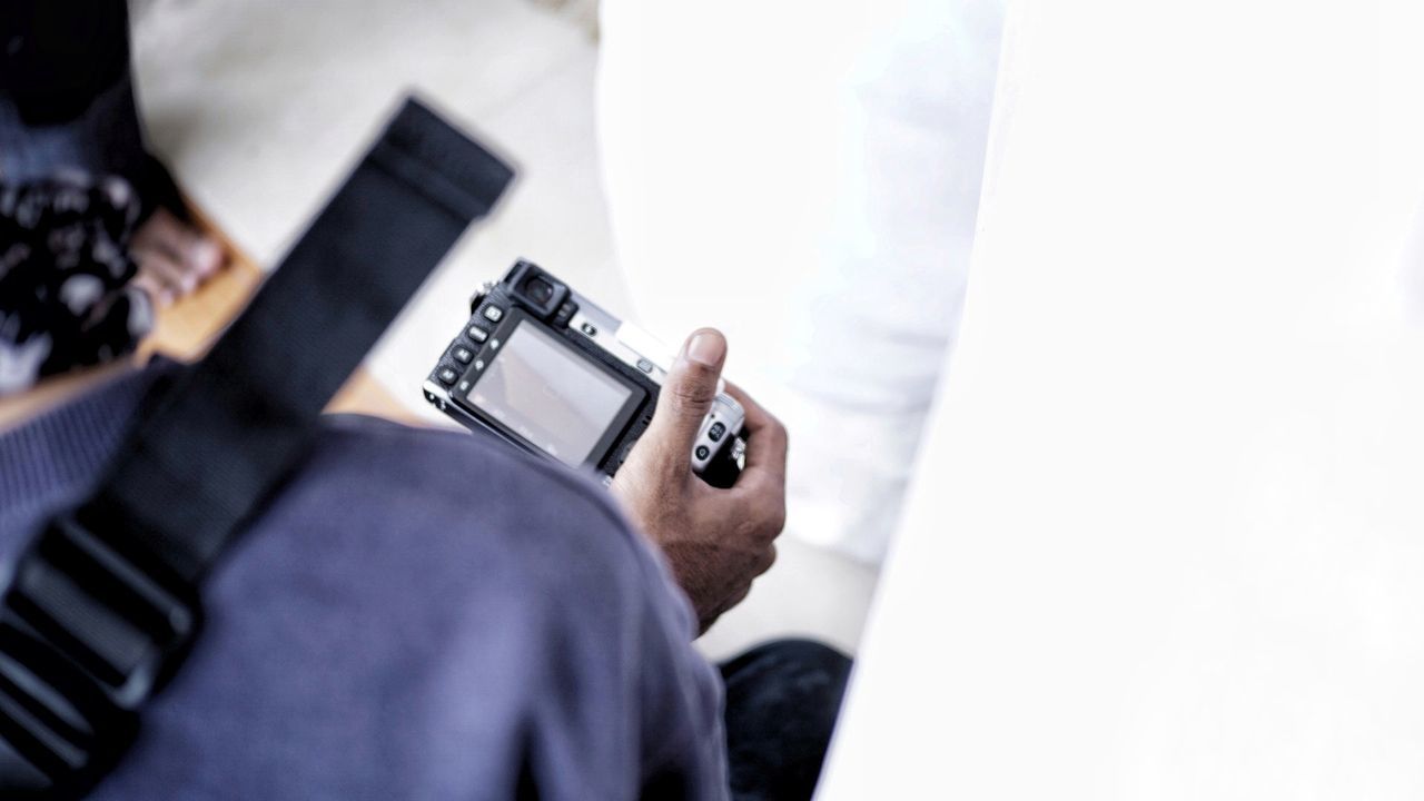 Cropped image of man holding camera