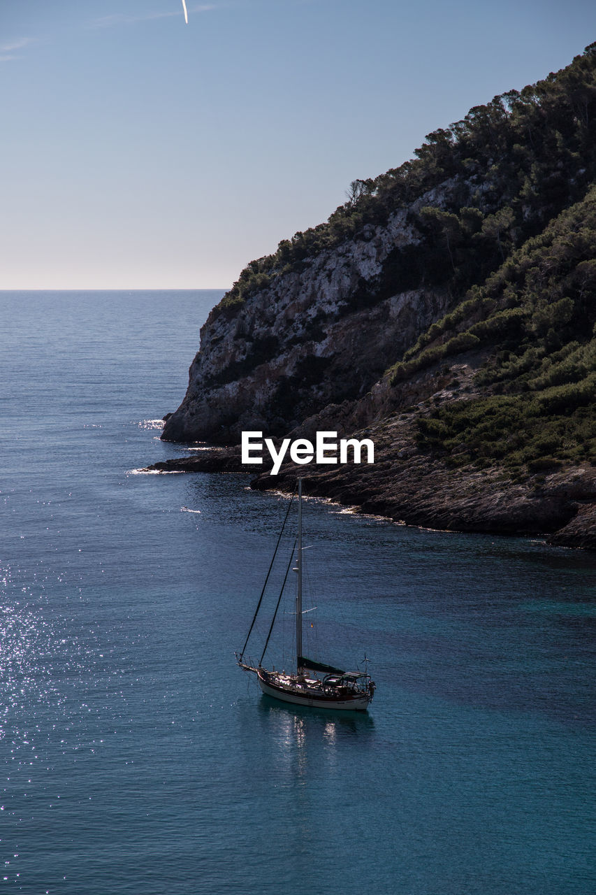 Sailboat on sea against clear sky