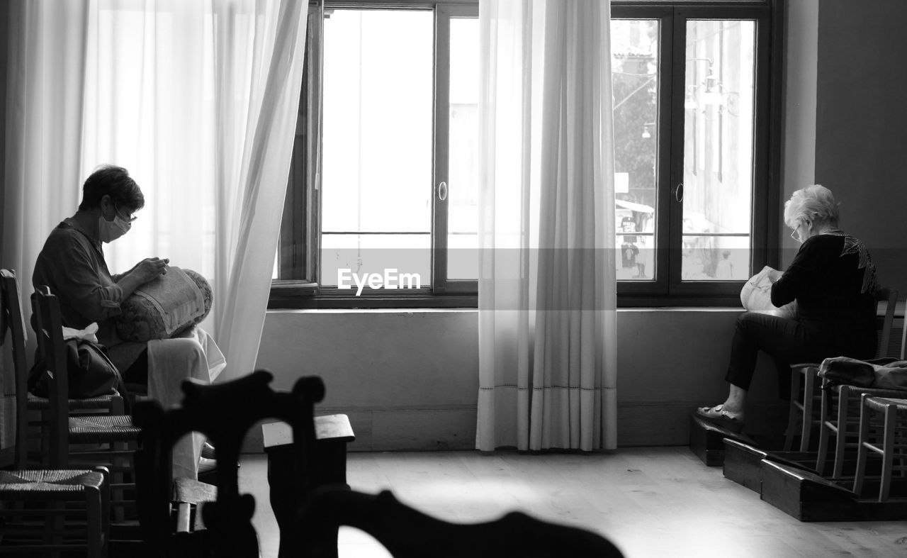 MAN SITTING ON CHAIR AT HOME