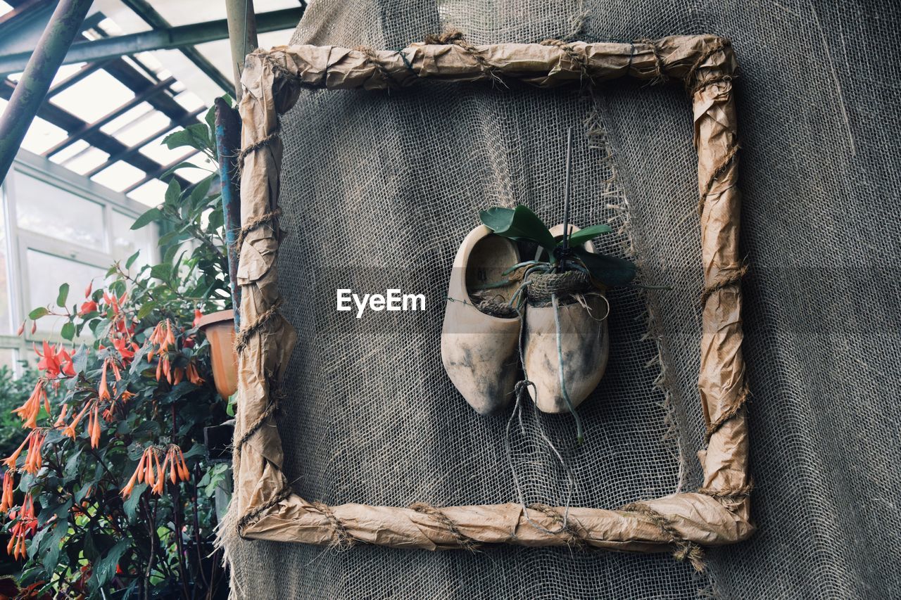 CLOSE-UP OF FLOWER POTS HANGING ON WOODEN WALL