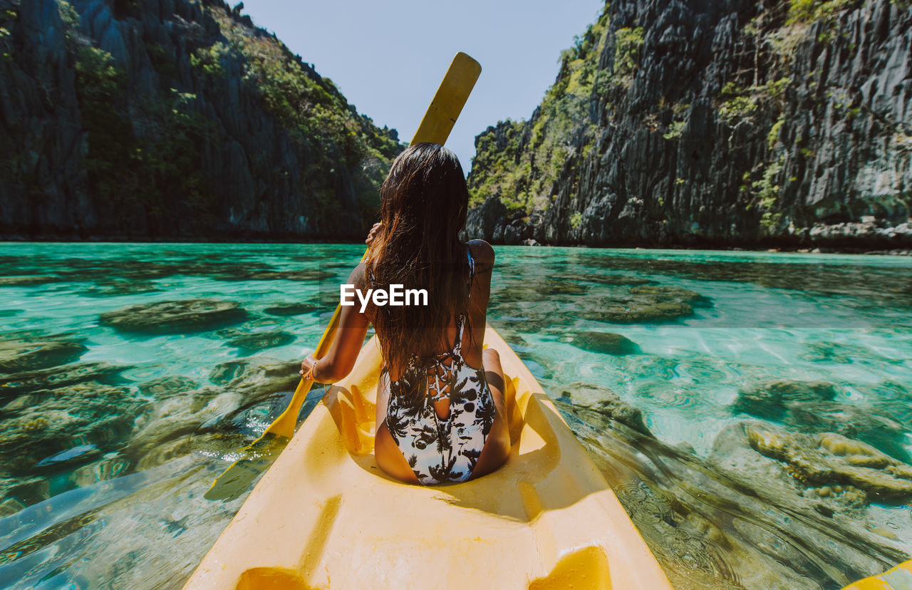 Rear view of woman kayaking in sea