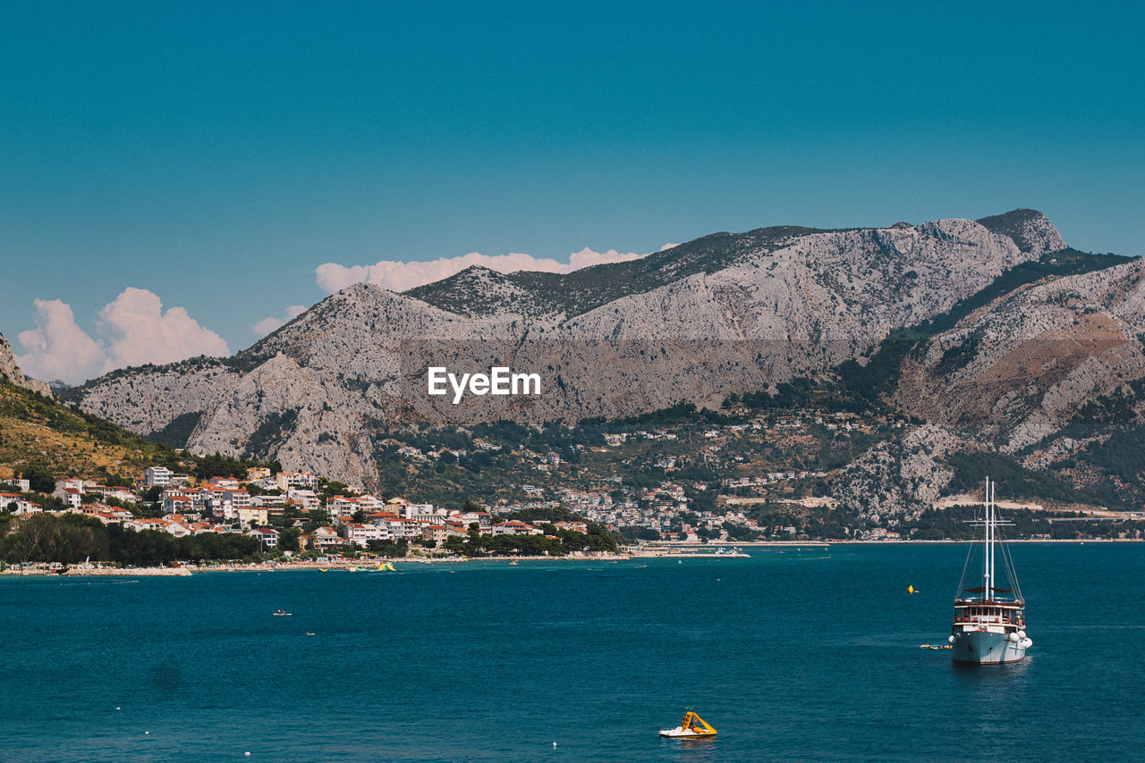 SAILBOATS IN SEA AGAINST CLEAR BLUE SKY