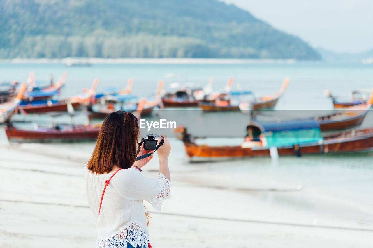 Rear view of woman photographing sea