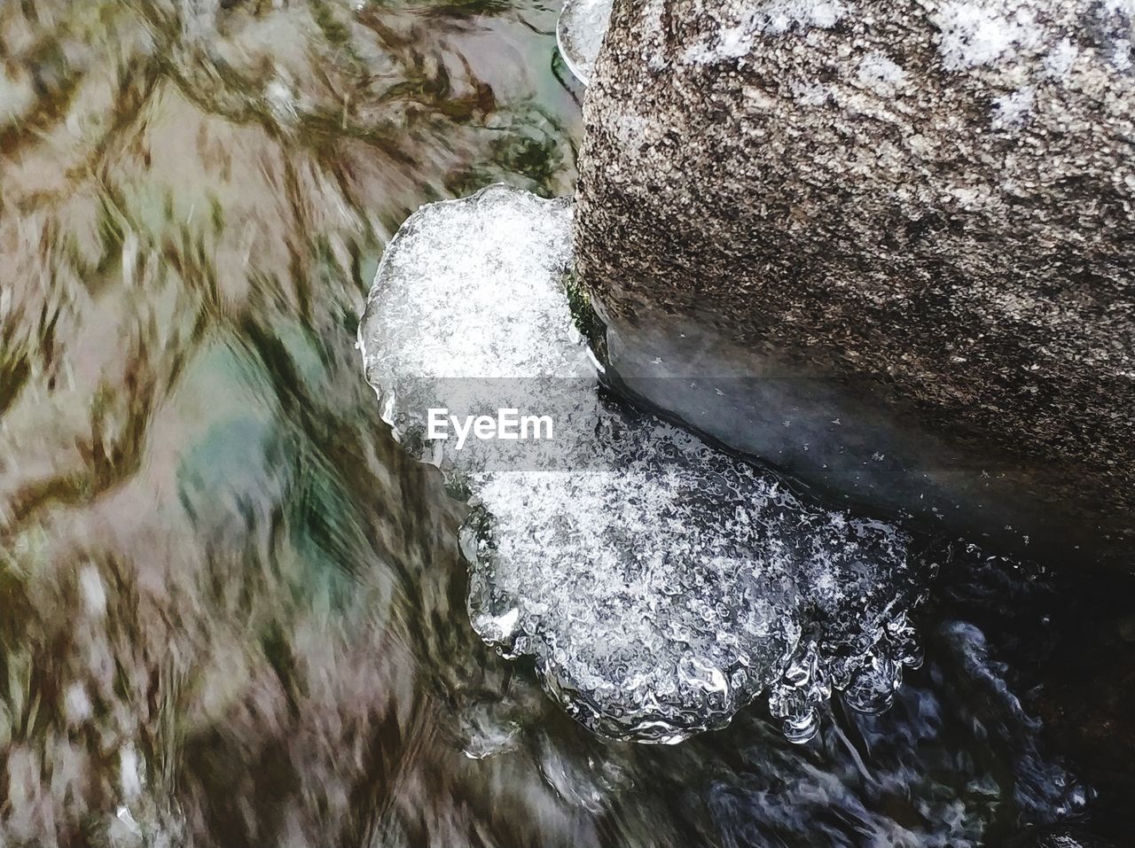 HIGH ANGLE VIEW OF WATER FLOWING OVER RIVER