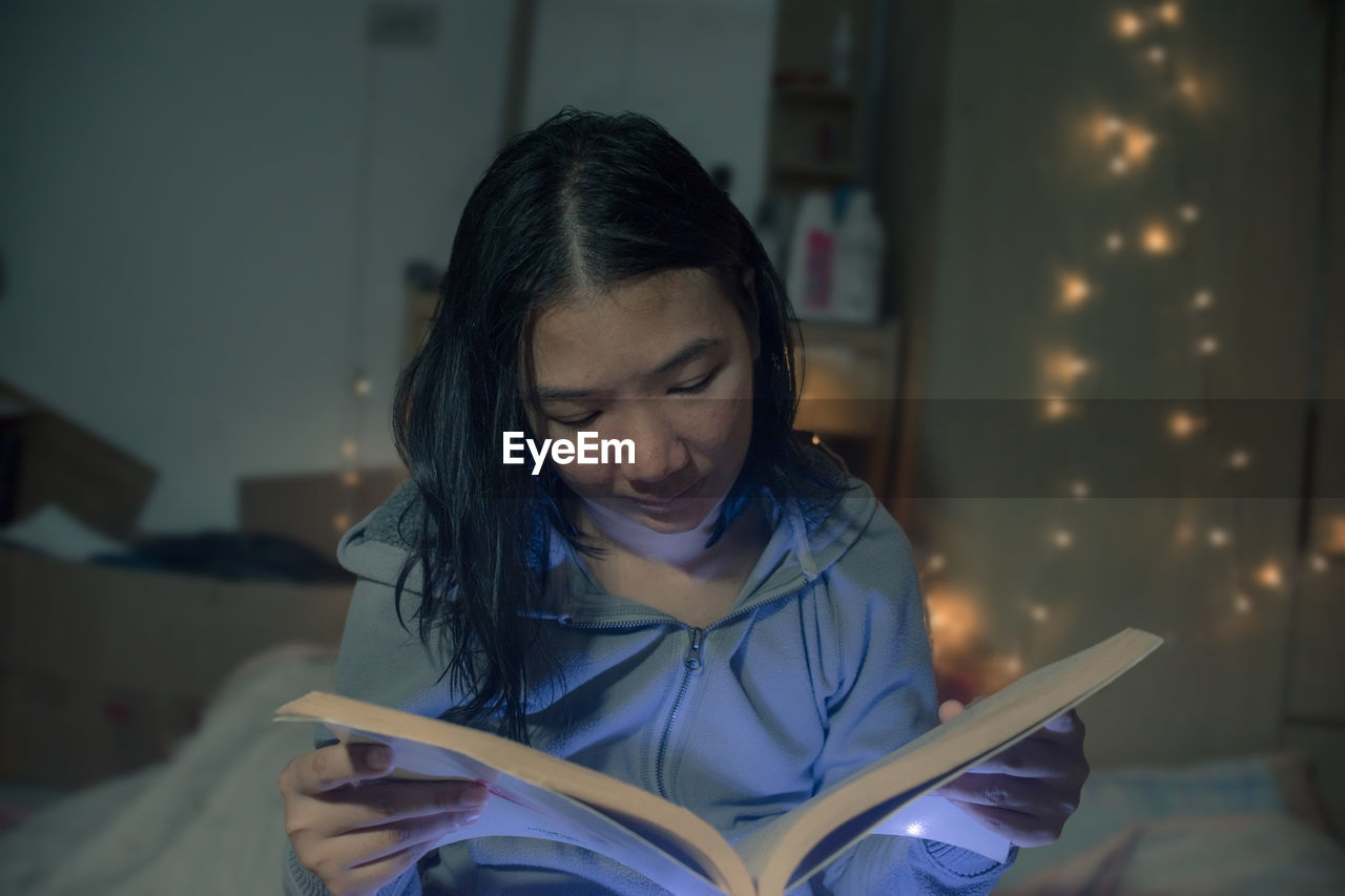 Woman reading book at home