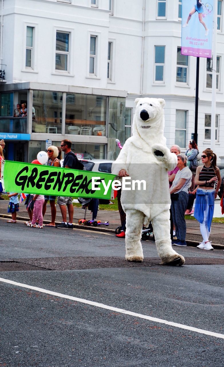 PEOPLE WALKING ON ROAD IN CITY