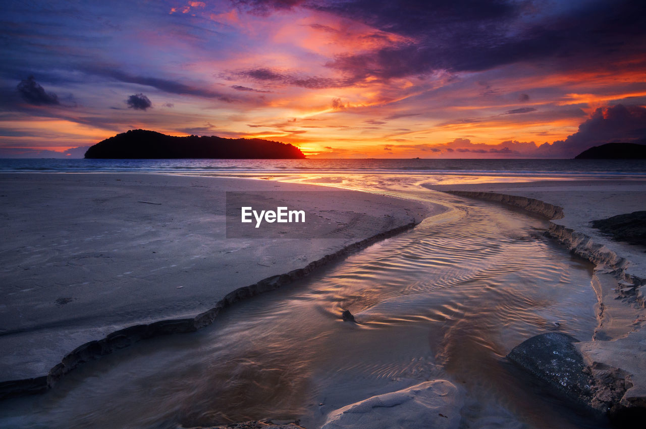 Scenic view of beach against sky during sunset