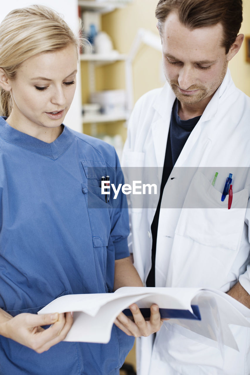 Doctor and nurse reading file in hospital