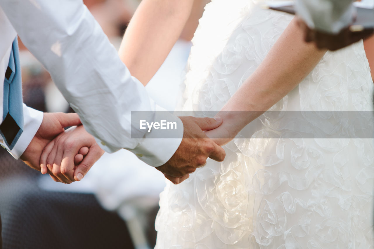 Close-up of wedding couple holding hands