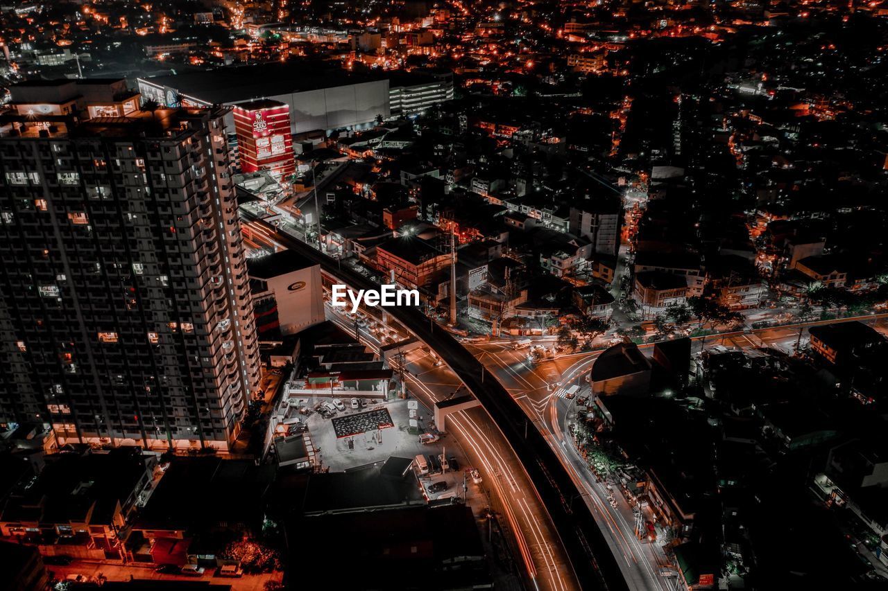 HIGH ANGLE VIEW OF ILLUMINATED BUILDINGS IN CITY