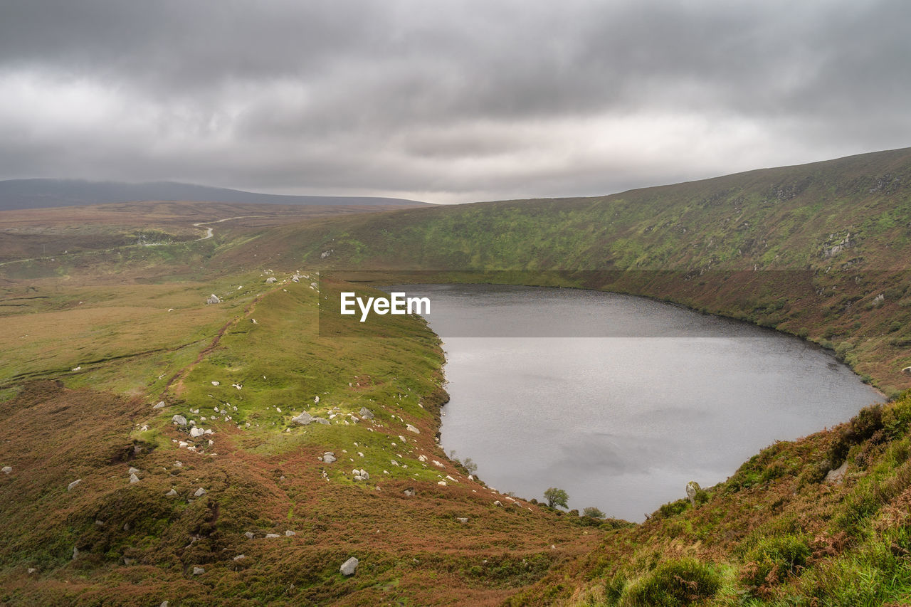 Lake, lough bray with mountain trail on the left and cliffs on right in wicklow mountains