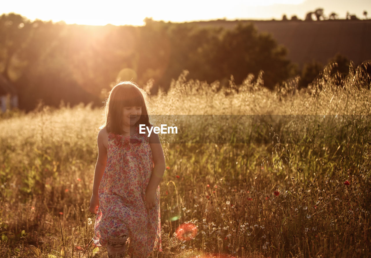 Full length of young girl standing on grassy field