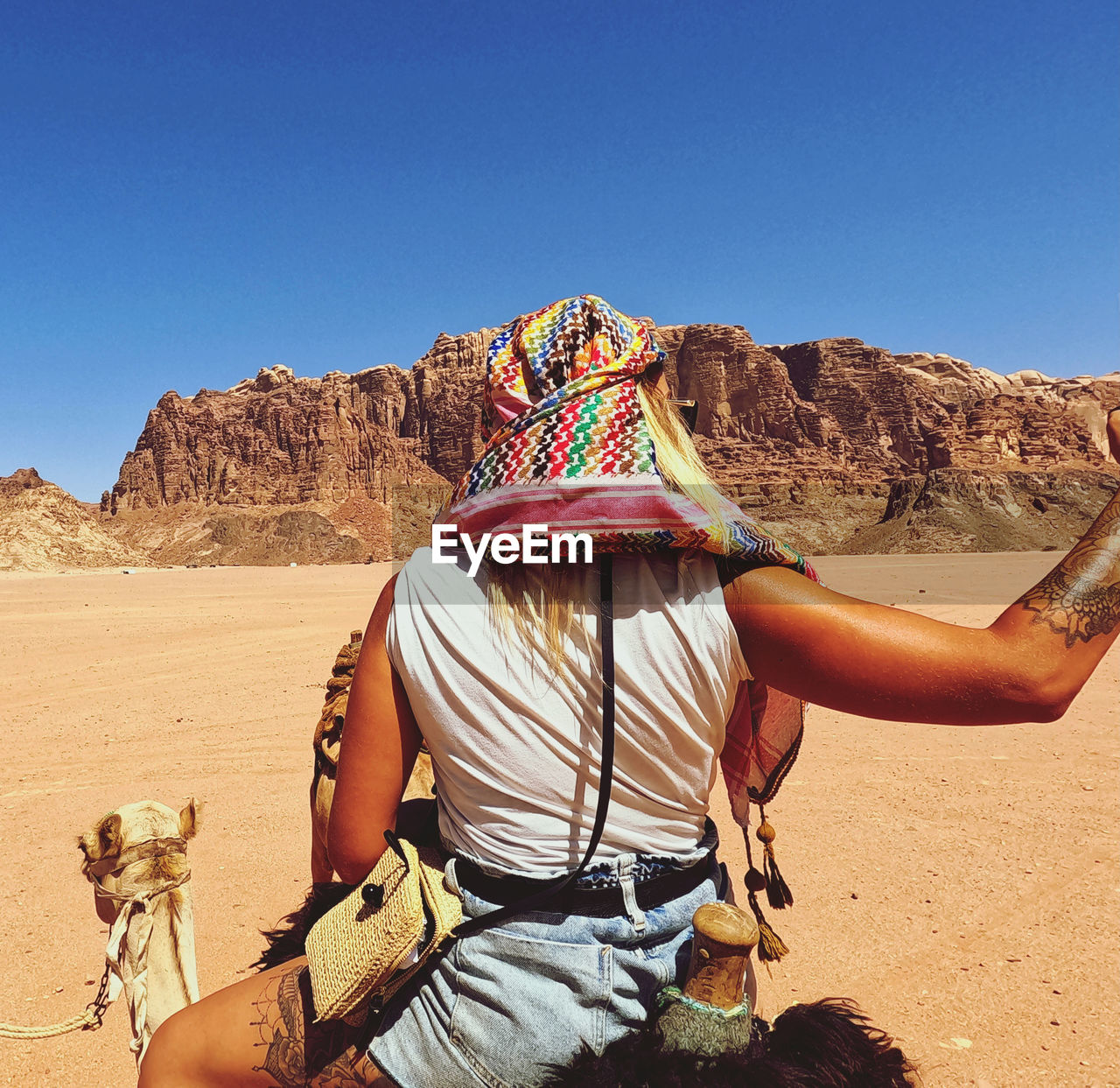 Midsection of person in desert against clear sky