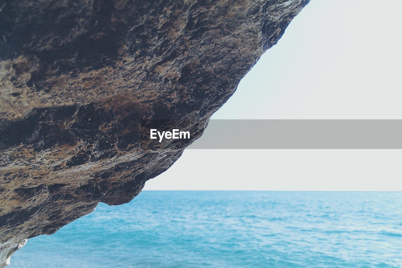 Cropped image of rock against sea