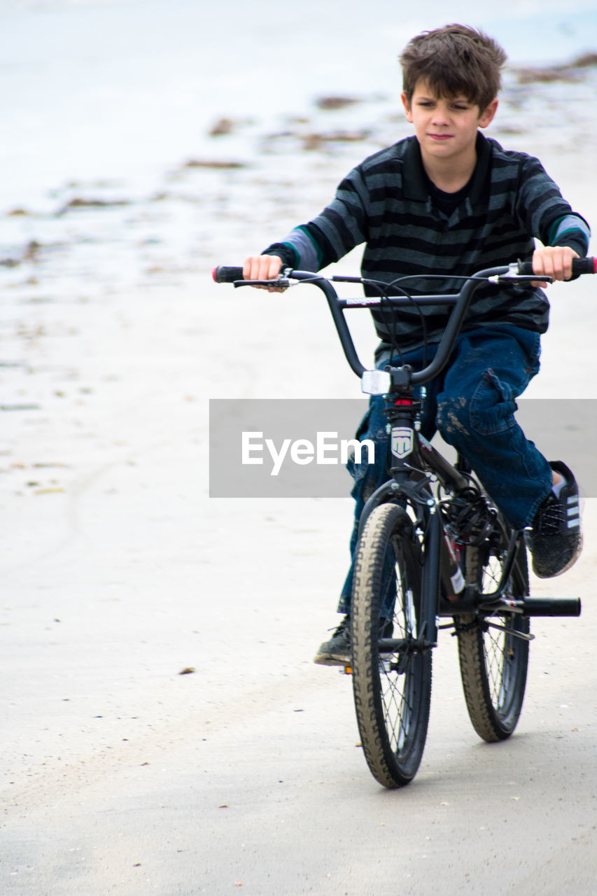 MAN WITH BICYCLE ON THE BEACH