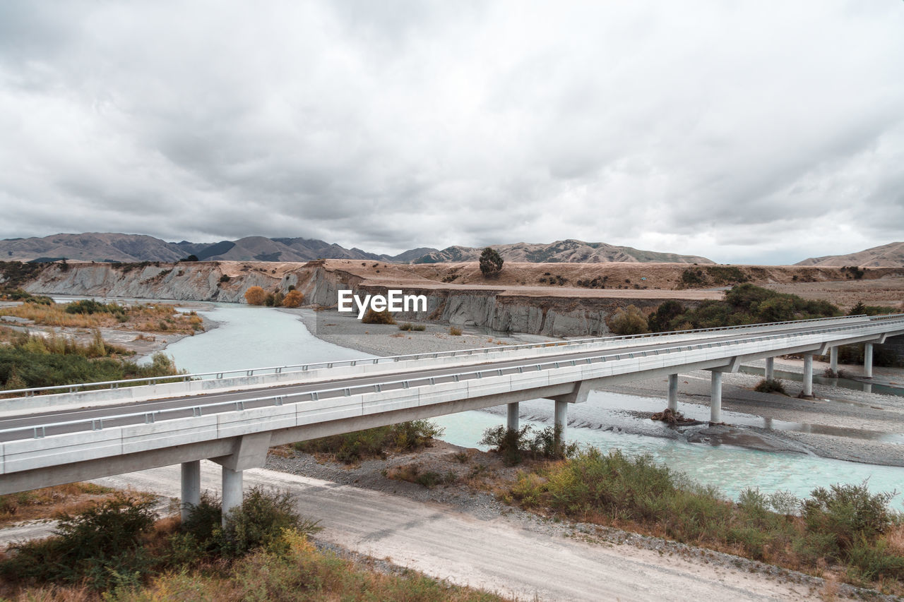 Bridge over river against cloudy sky