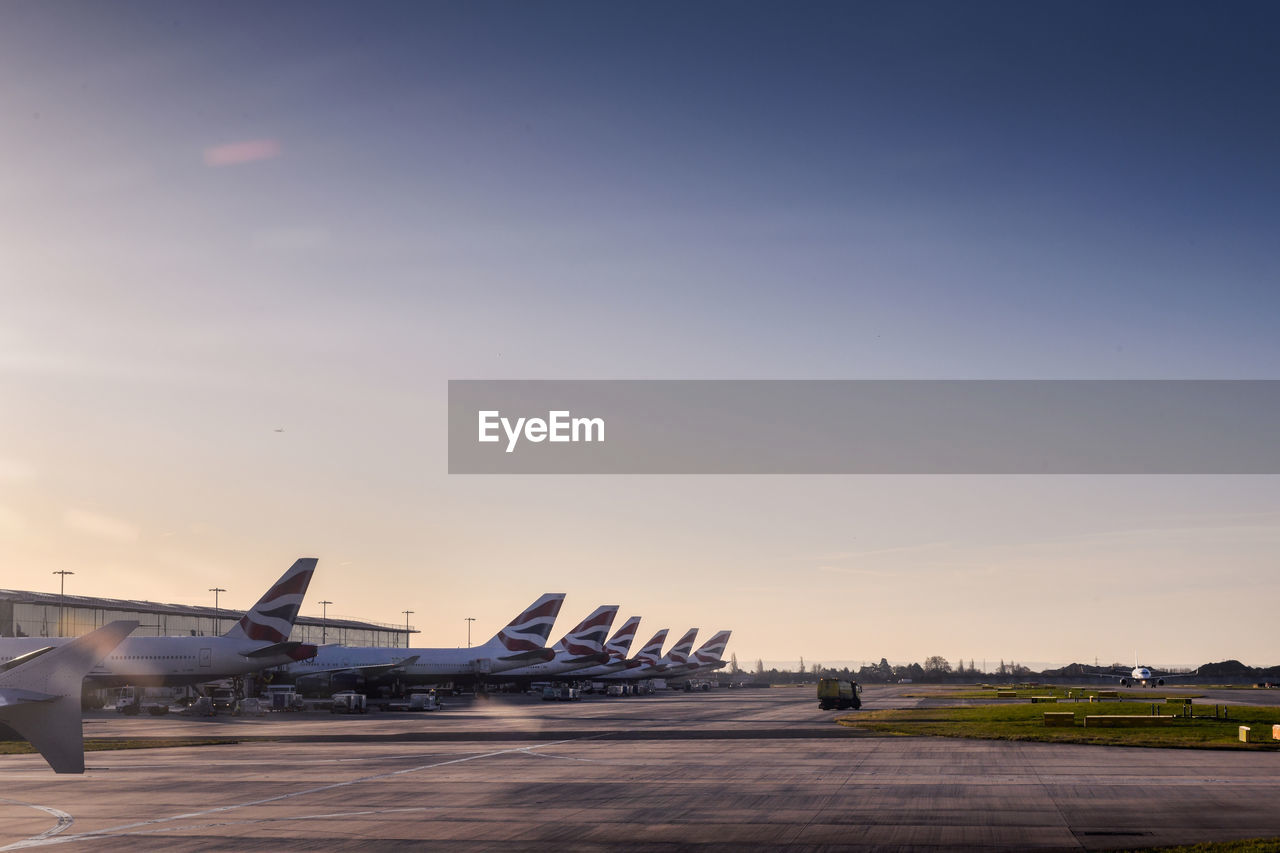 AIRPLANE FLYING OVER RUNWAY AGAINST SKY