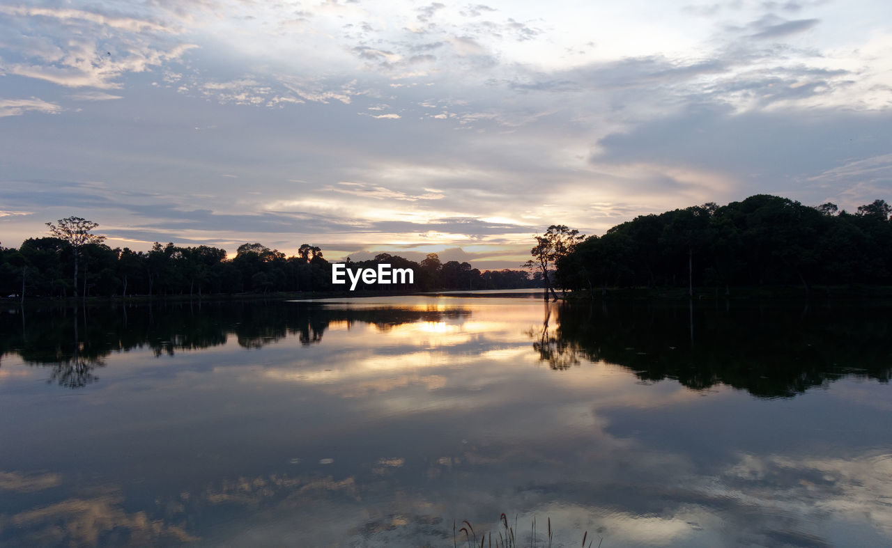 reflection, water, sky, nature, lake, cloud, beauty in nature, tranquility, scenics - nature, morning, tree, tranquil scene, environment, dawn, plant, landscape, no people, reservoir, body of water, reflection lake, sunrise, outdoors, travel destinations, forest, idyllic, land, sun, mountain, non-urban scene, twilight, sunlight, travel, beach