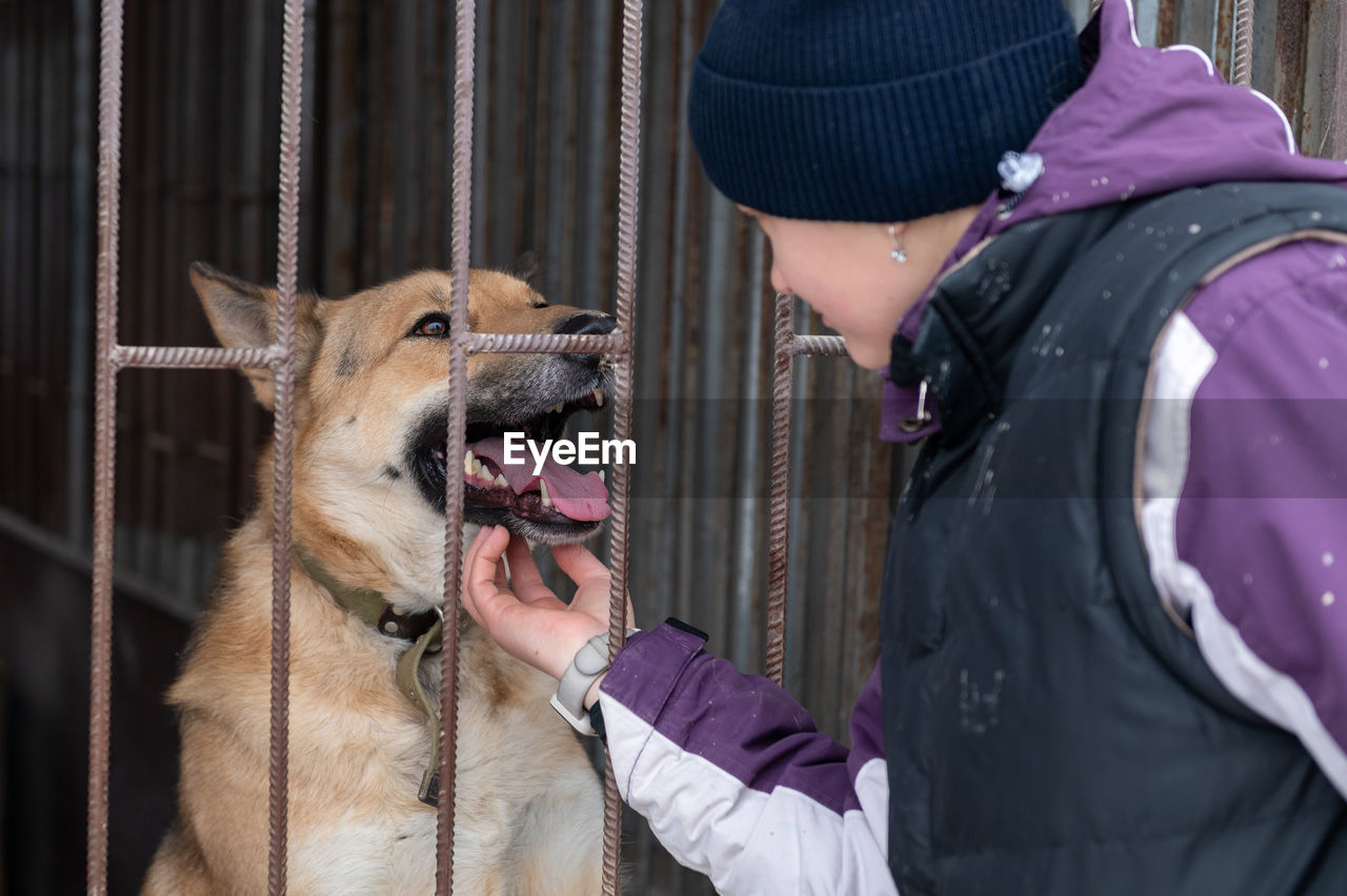 Girl volunteer in the nursery for dogs. shelter for stray dogs.