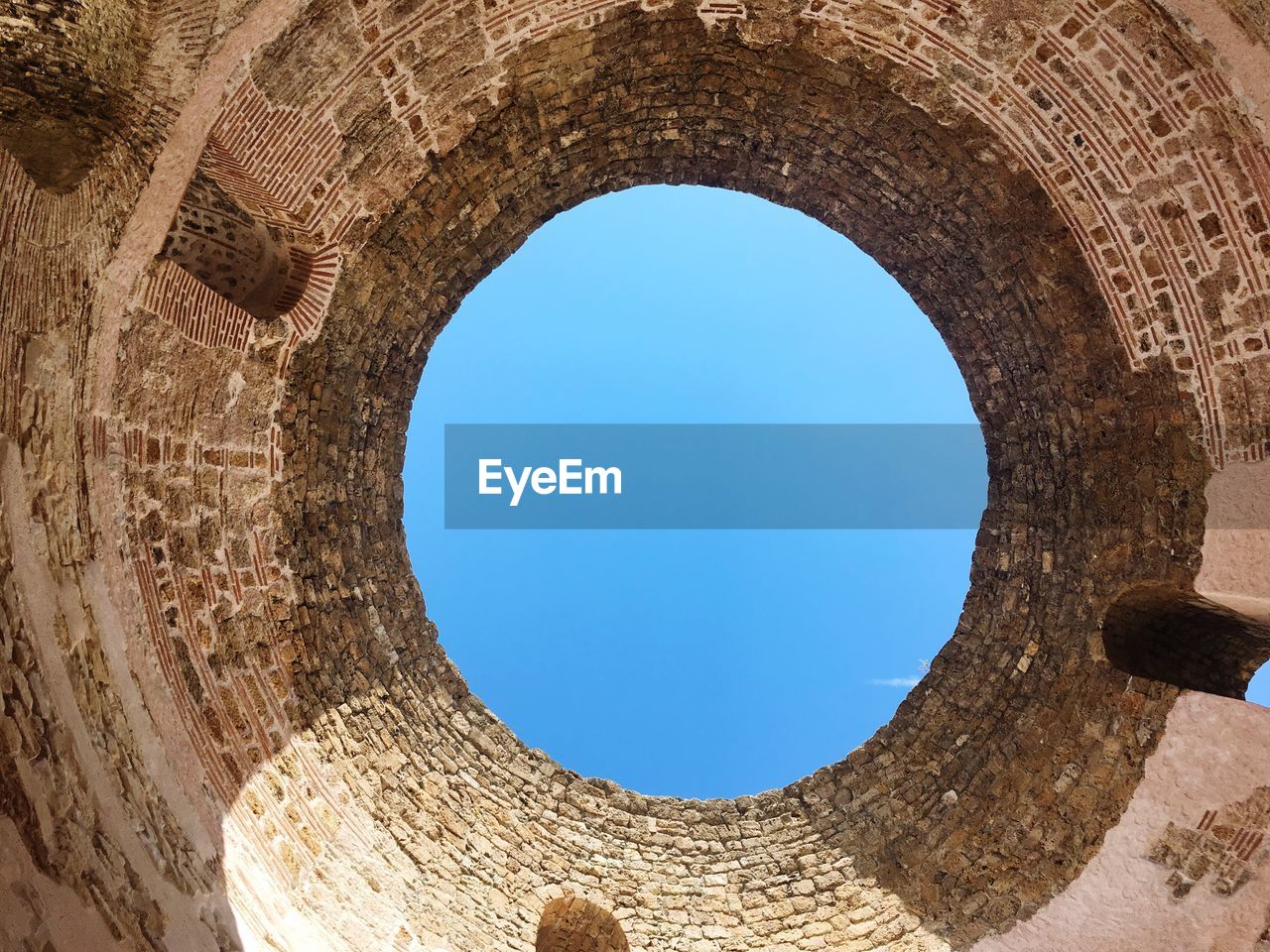 Low angle view of blue sky seen through hole