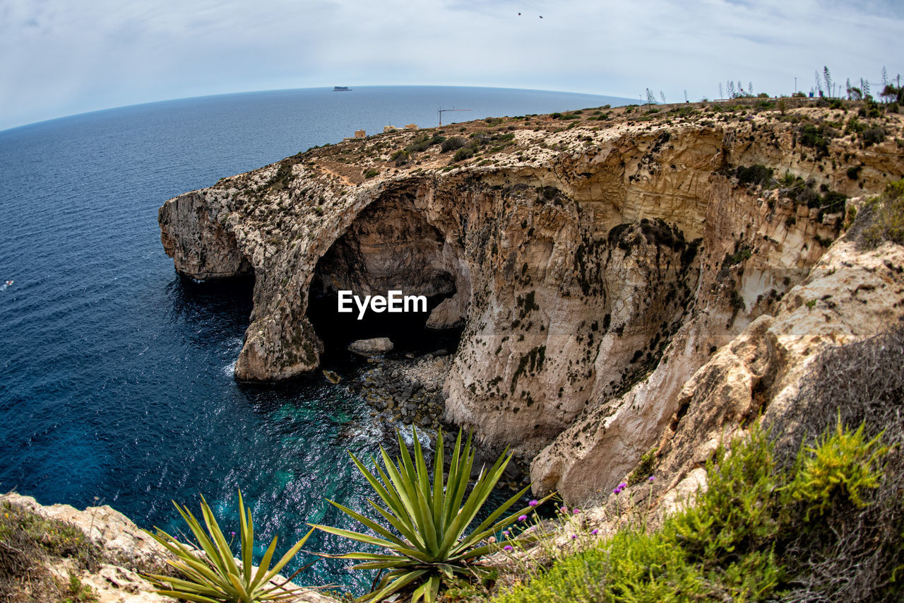 Scenic view of rock formation in sea against sky