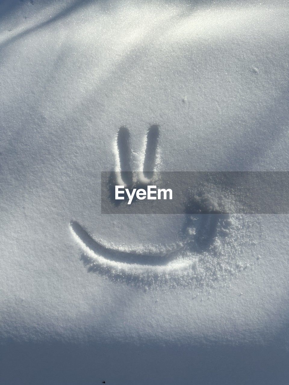 Smiley drawn on the snow. sunny winter day