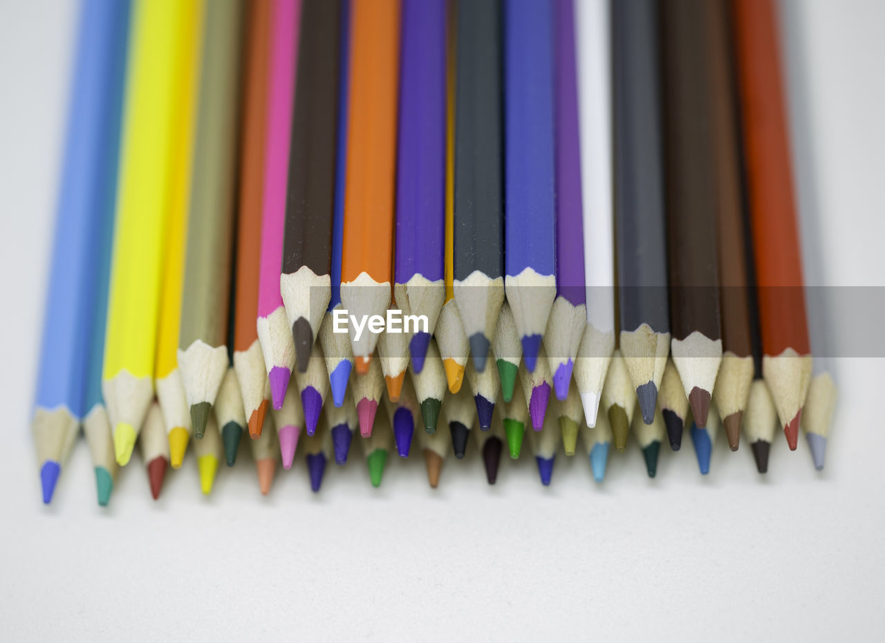 CLOSE-UP OF MULTI COLORED PENCILS IN ROW