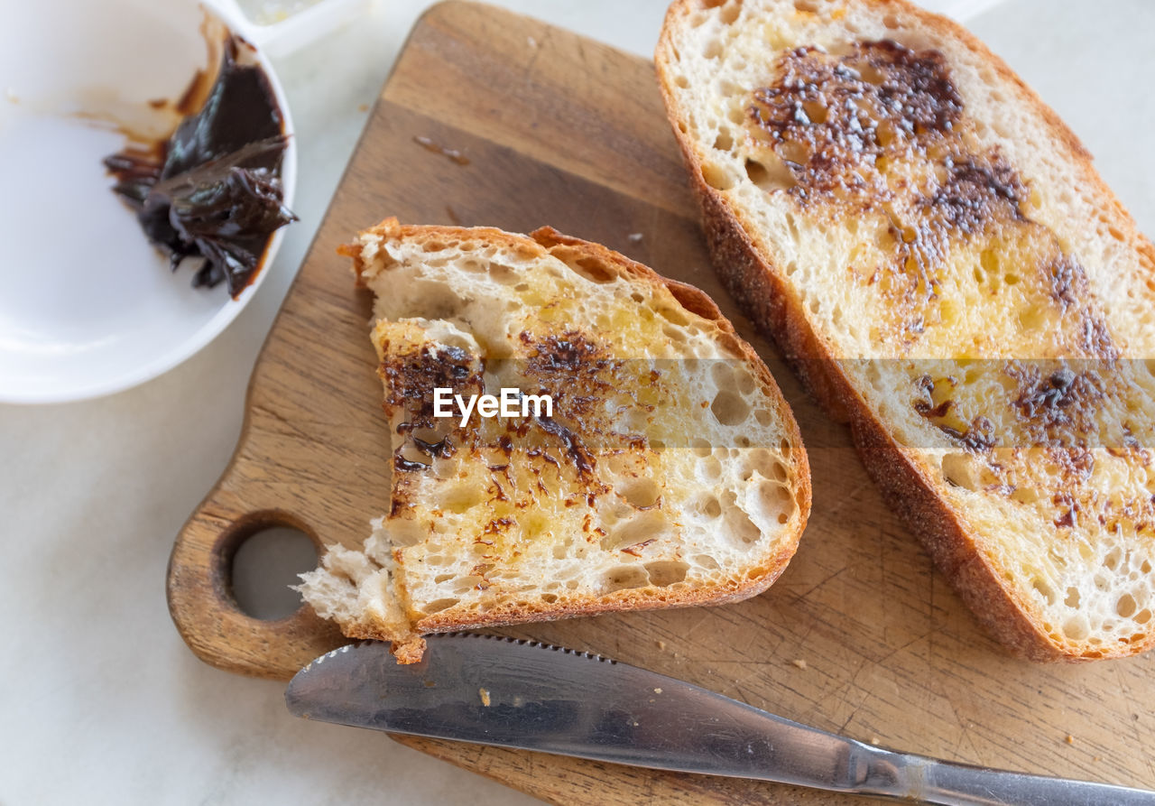 High angle view of bread on cutting board at table