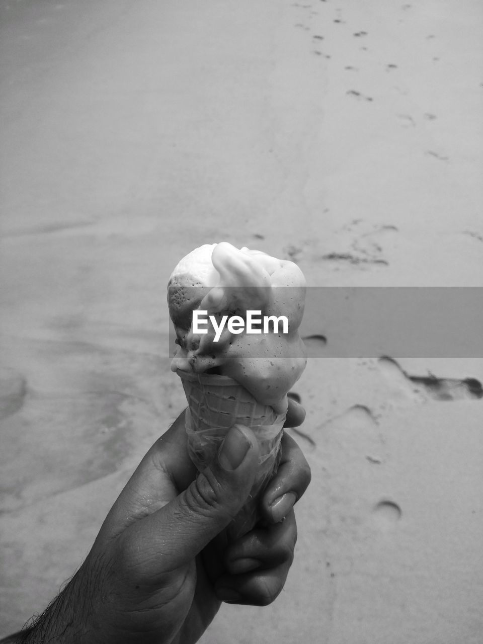 HUMAN HAND HOLDING ICE CREAM CONE