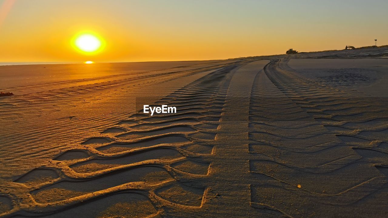 SCENIC VIEW OF BEACH AGAINST SKY AT SUNSET