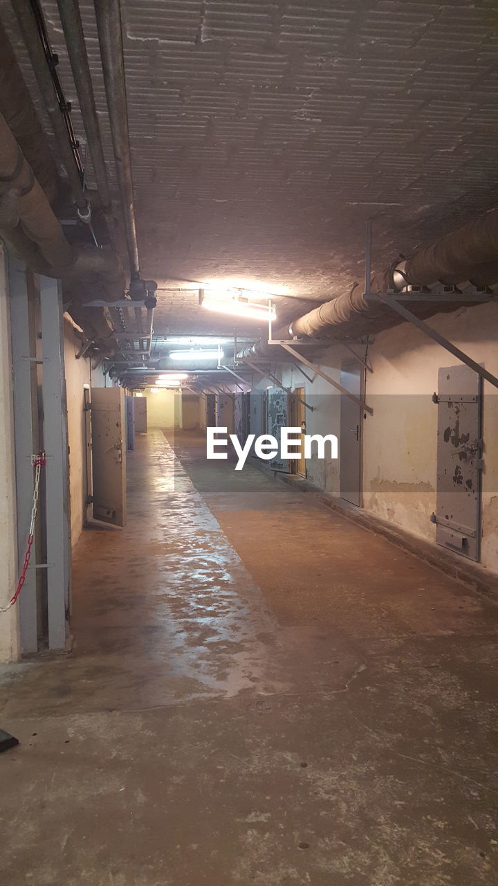 EMPTY ILLUMINATED TUNNEL WITH BUILDINGS IN BACKGROUND