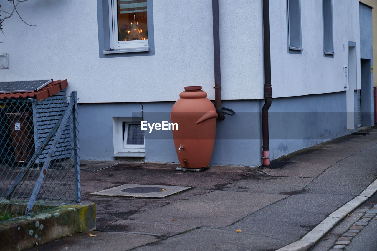 architecture, urban area, building exterior, street, built structure, road, wall, building, no people, house, city, facade, day, window, road surface, waste container, alley, outdoors, home, entrance, residential district, door, asphalt, neighbourhood, footpath, lane