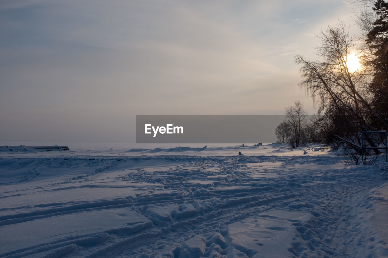 Scenic view of snow covered land against sky during winter