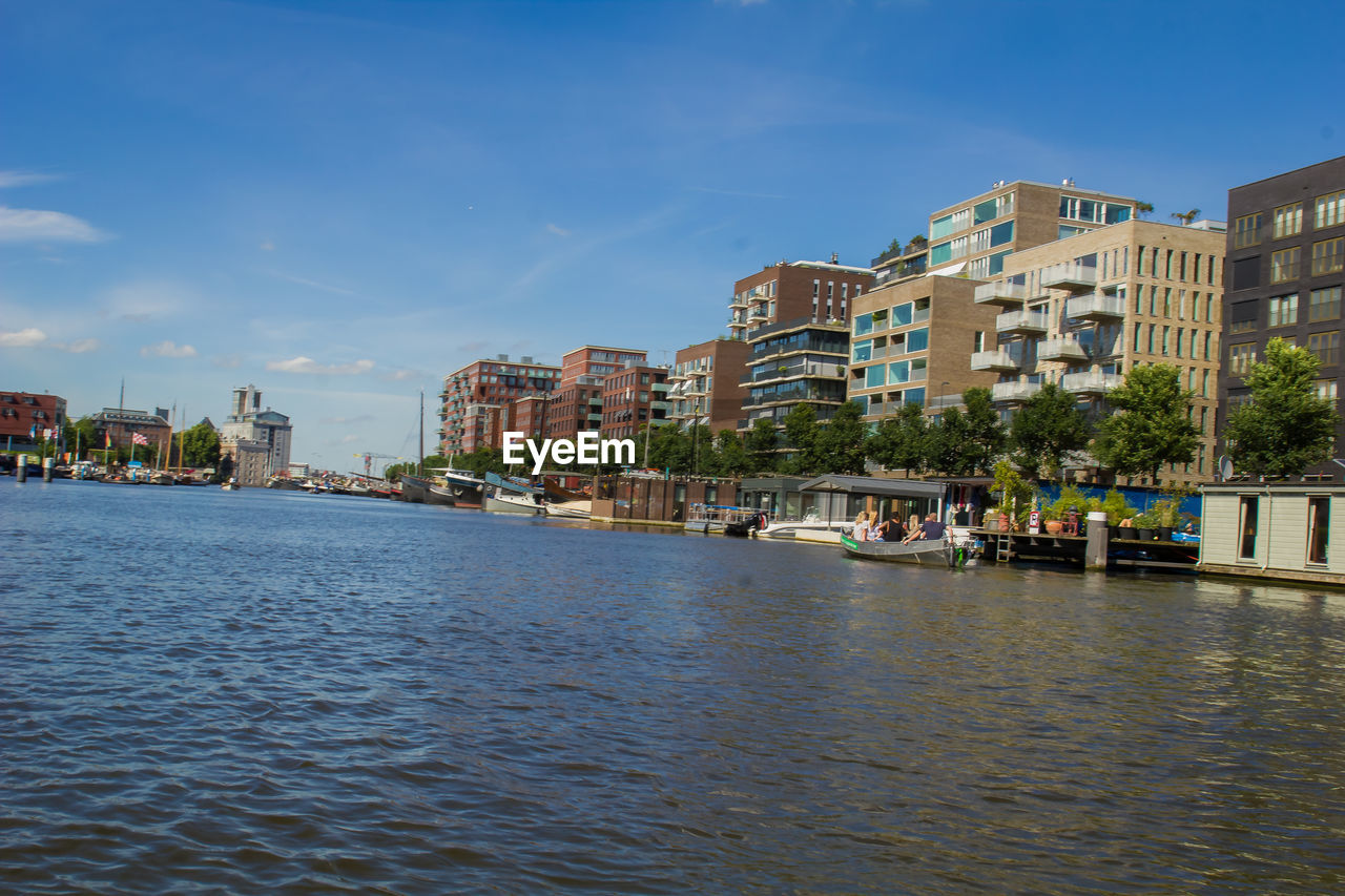 Boats in river with buildings in background