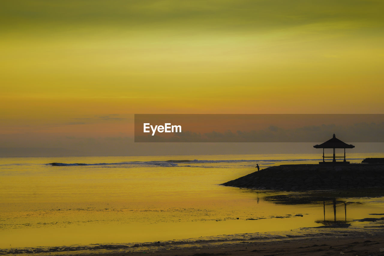 Scenic view of beach against sky during sunset