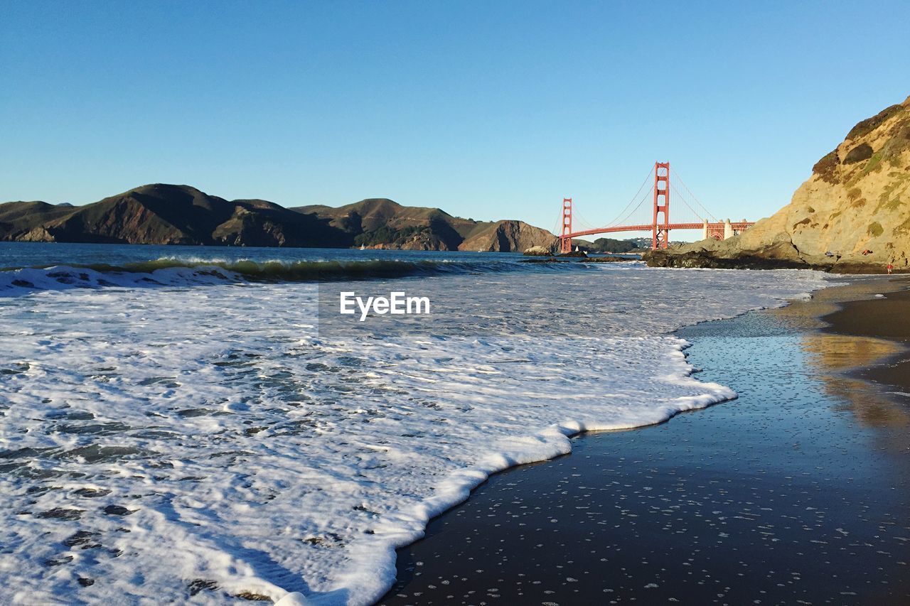 Low angle view of golden gate bridge on river against clear blue sky
