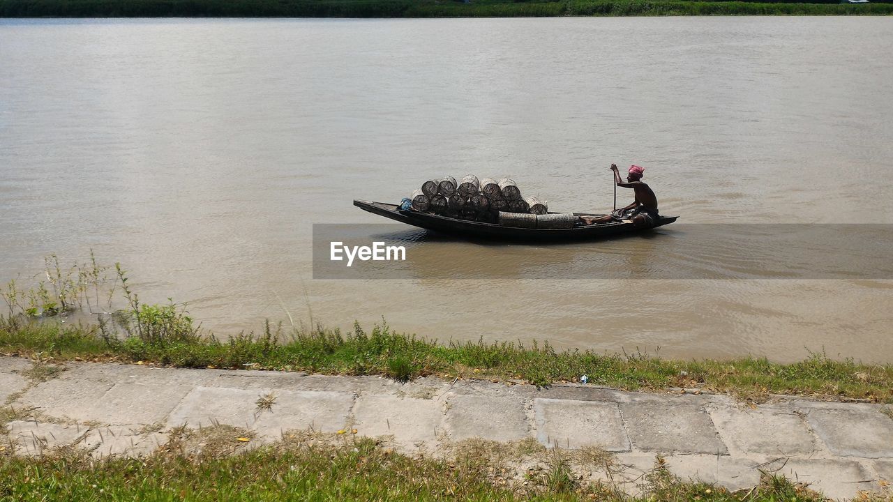 MAN ROWING BOAT ON WATER