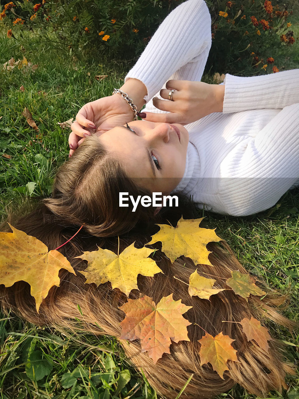 High angle portrait of woman lying down on field