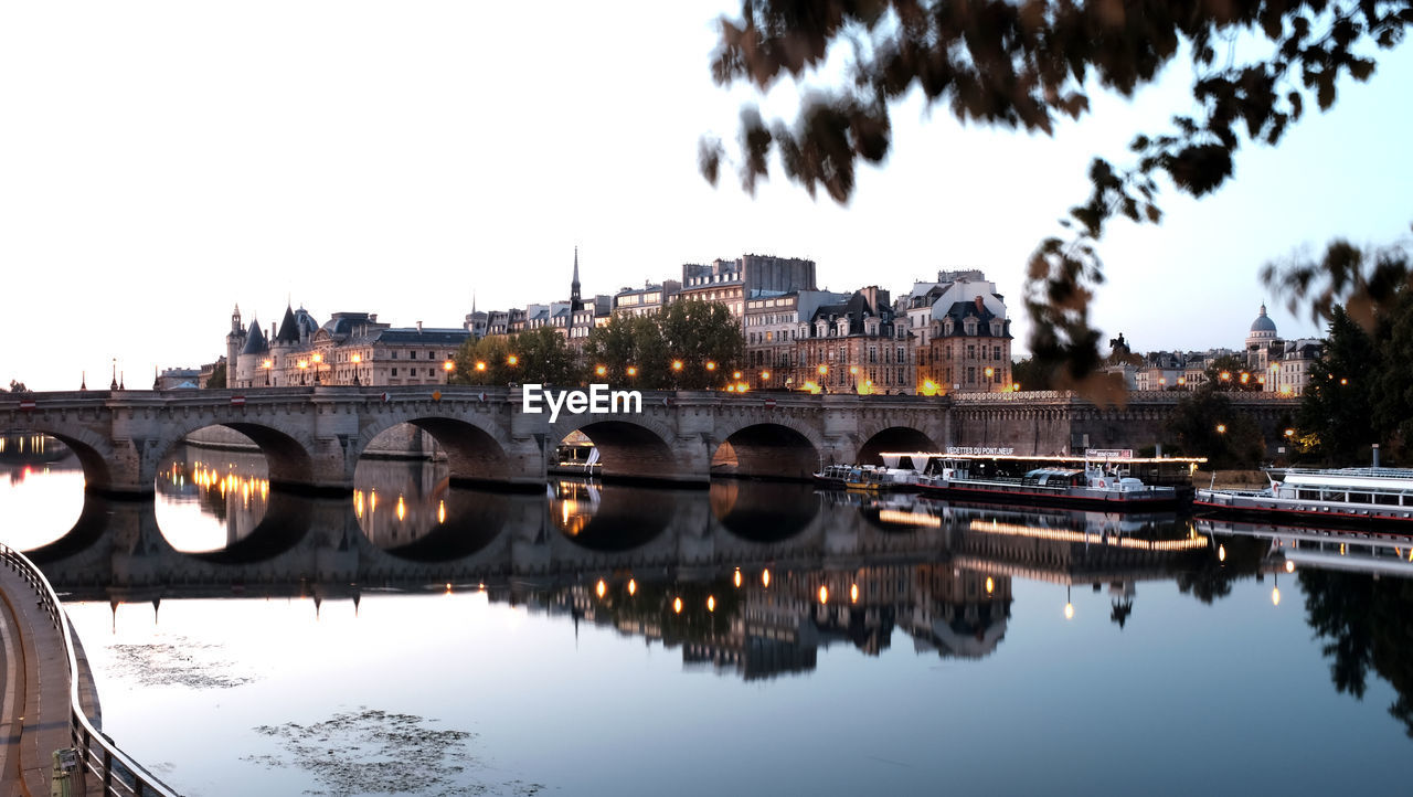 Bridge over river against sky in city