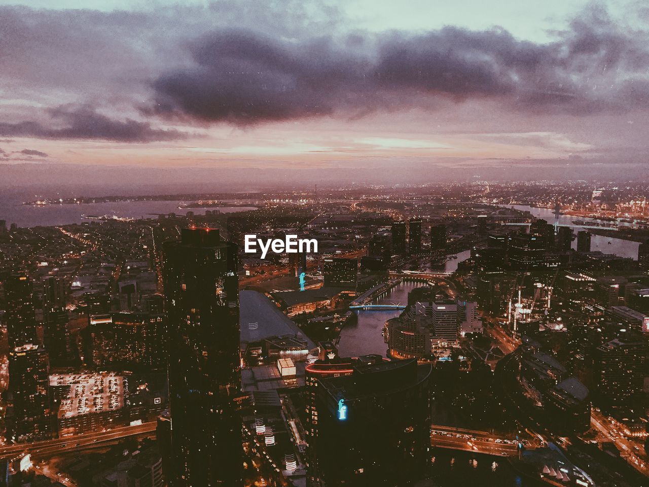 High angle view of illuminated city against sky at dusk