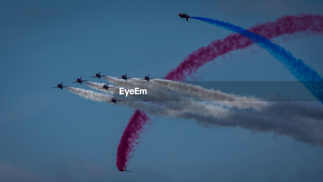 LOW ANGLE VIEW OF AIRSHOW AGAINST SKY