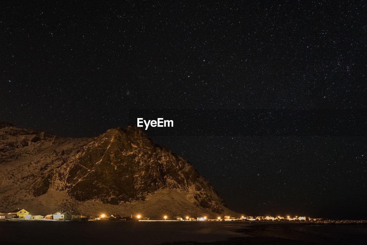 Scenic view of mountain against star field at night during winter
