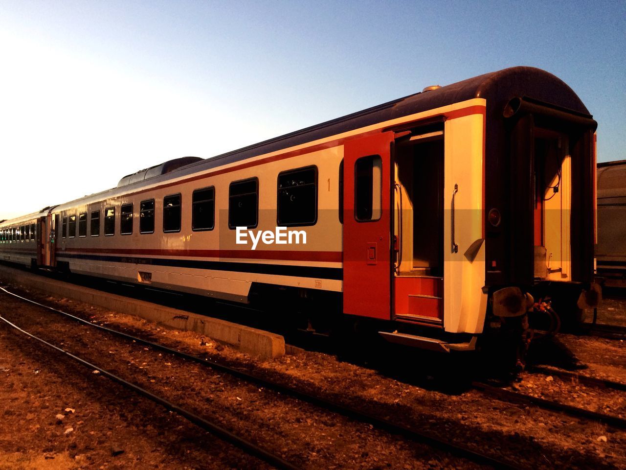 TRAIN AT RAILROAD STATION AGAINST SKY