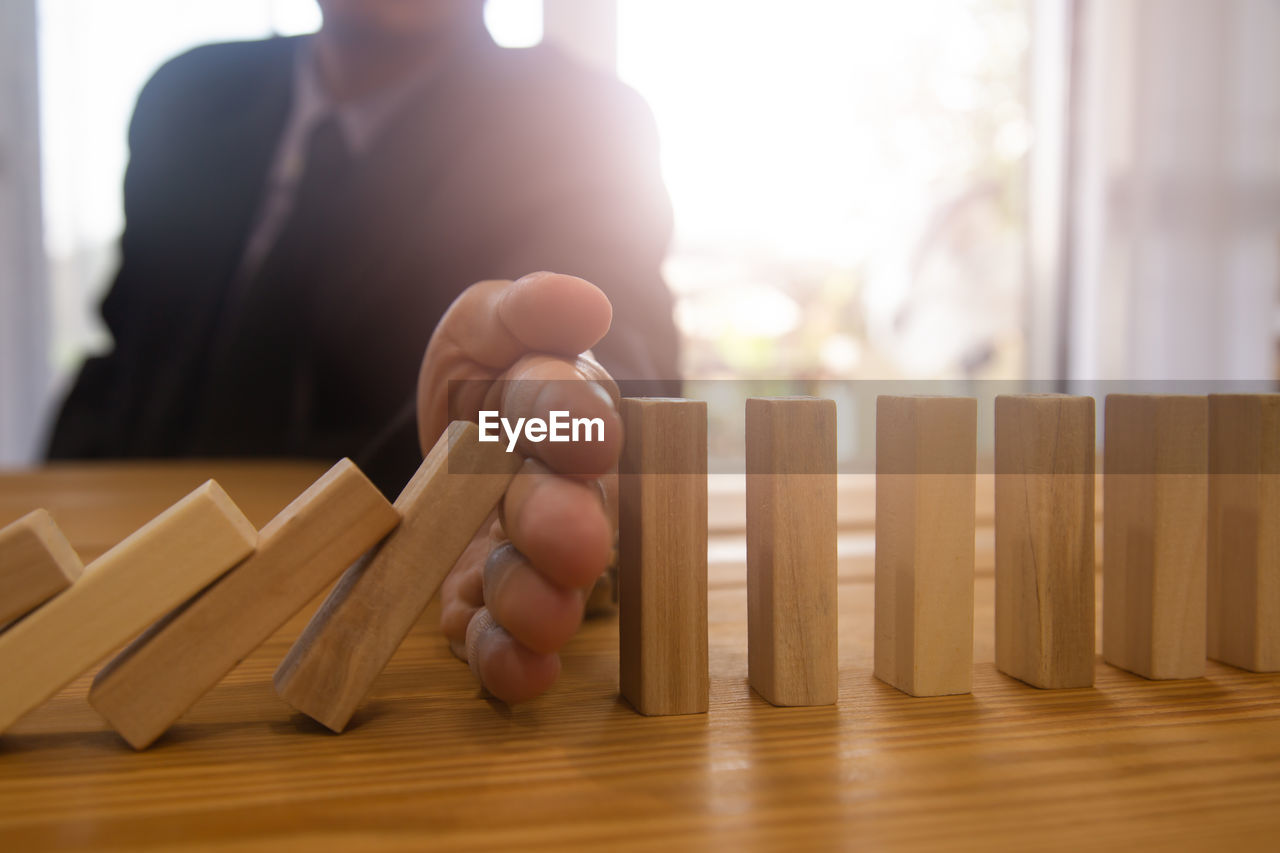 adult, indoors, business, wood, men, one person, occupation, back lit, working, table, lens flare, hardwood, sunlight, businessman, window, day, hand, focus on foreground, business finance and industry, selective focus