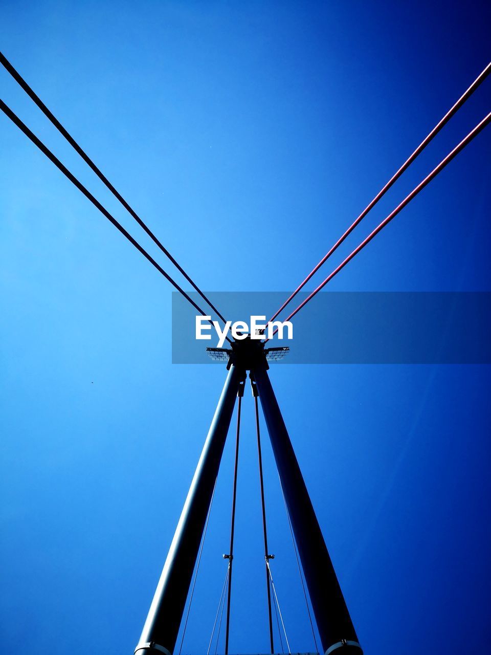 LOW ANGLE VIEW OF CRANES AGAINST CLEAR BLUE SKY