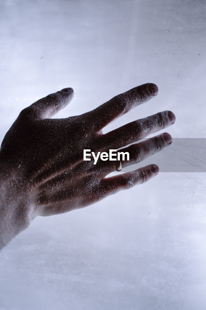 High angle view of human hand with flour on table