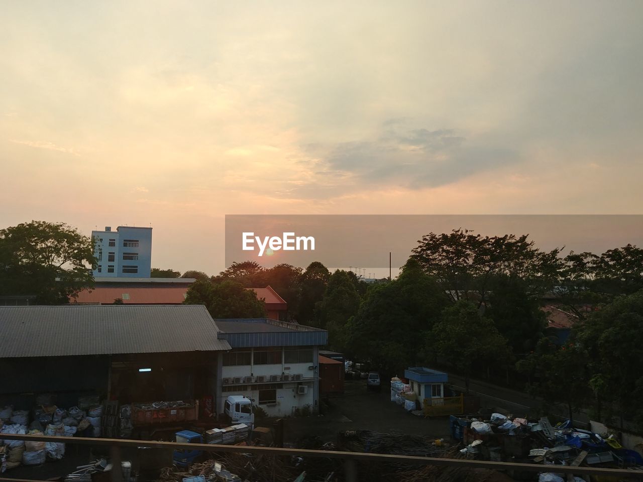 HIGH ANGLE VIEW OF BUILDINGS AGAINST SKY AT SUNSET