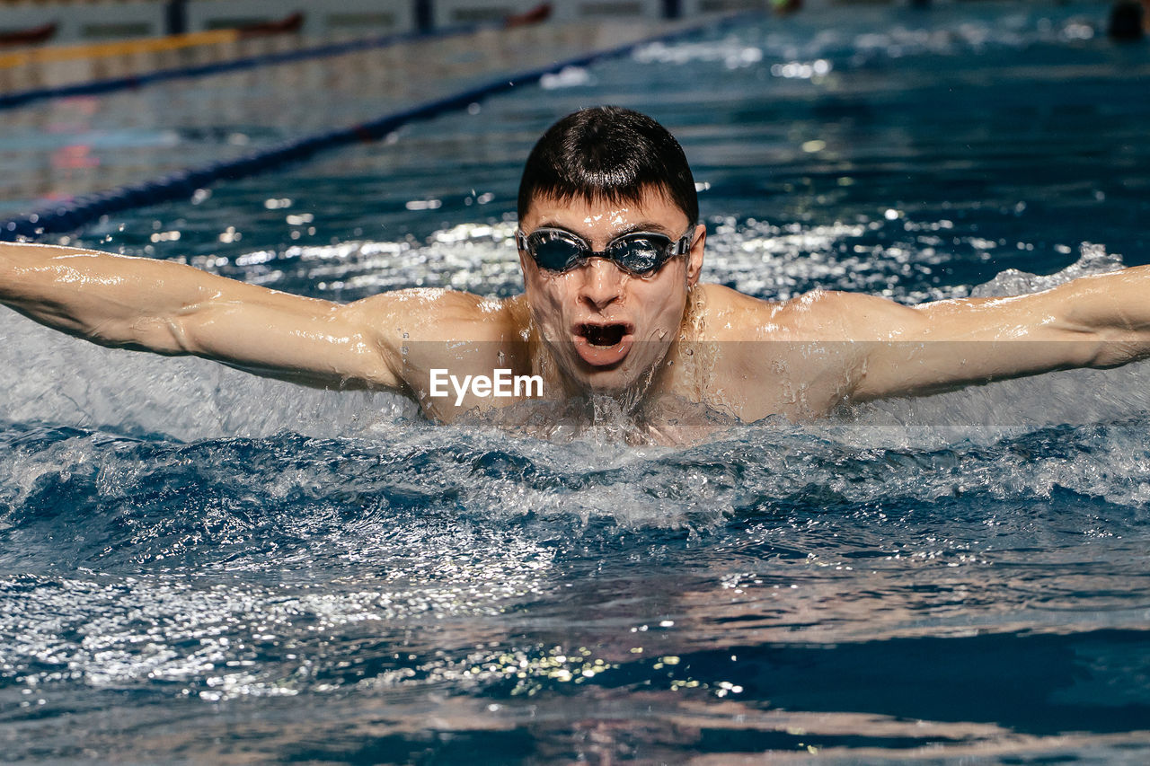 Portrait of young man swimming in pool